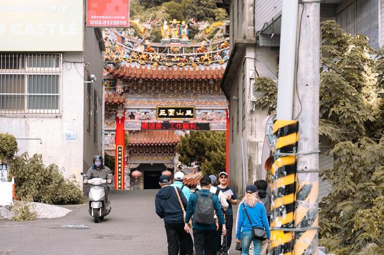 民眾走過廟宇牌樓，準備進行古蹟廟宇走讀