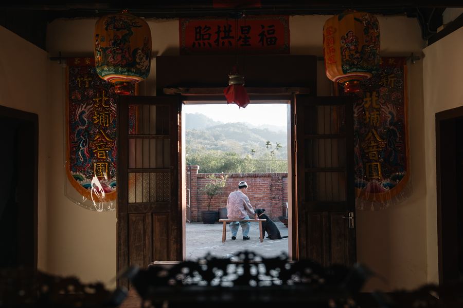 從廳堂望出，門框兩側掛著彩繡燈籠