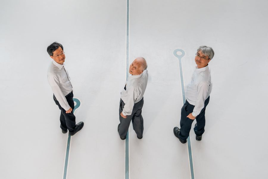 俯視角度，三位白襯衫男士回頭望向鏡頭