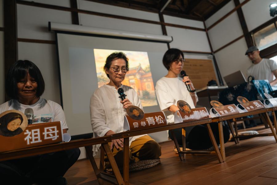 講座現場，三位講者坐在標示角色名的矮桌後